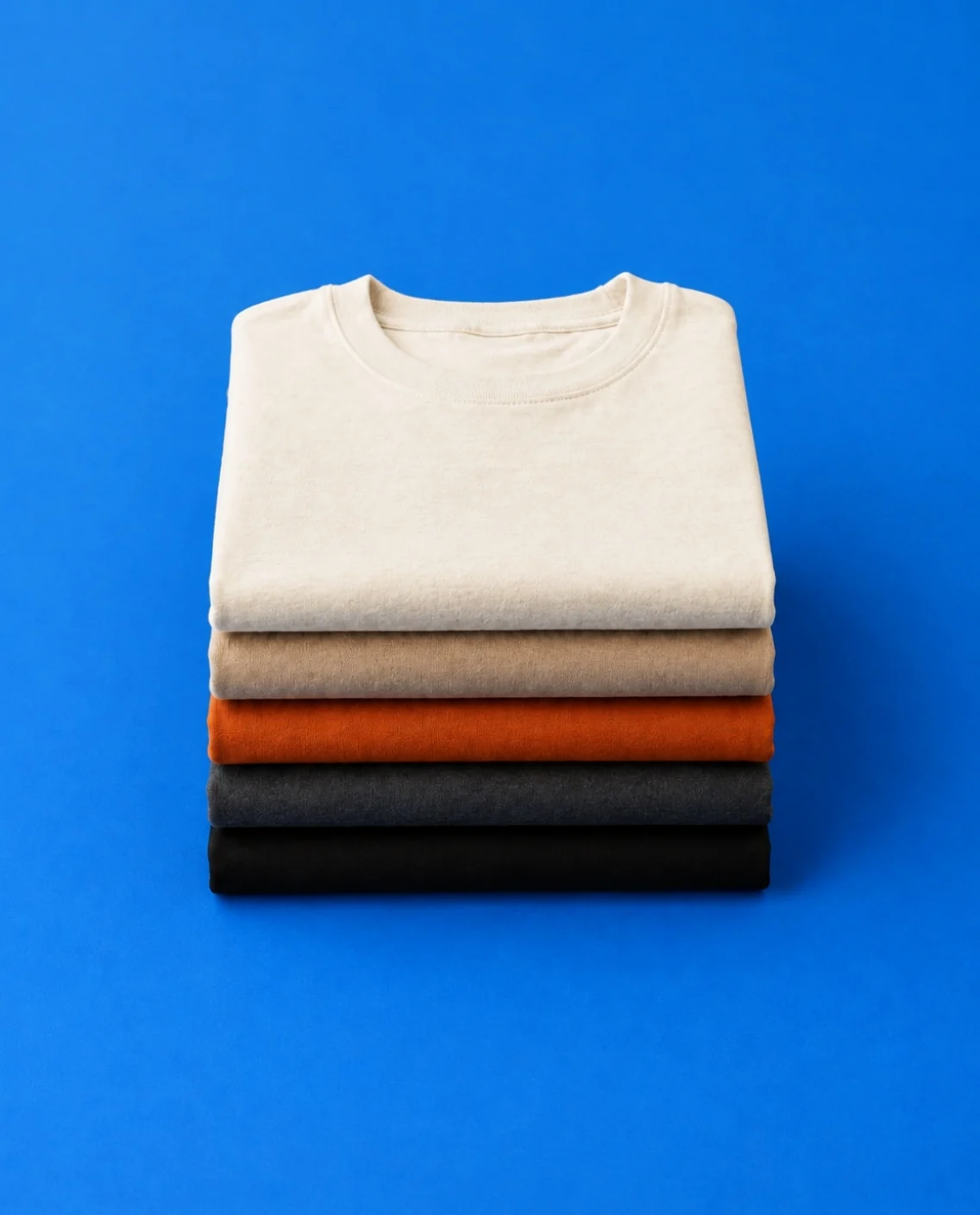 Pila de playeras dobladas sobre fondo azul